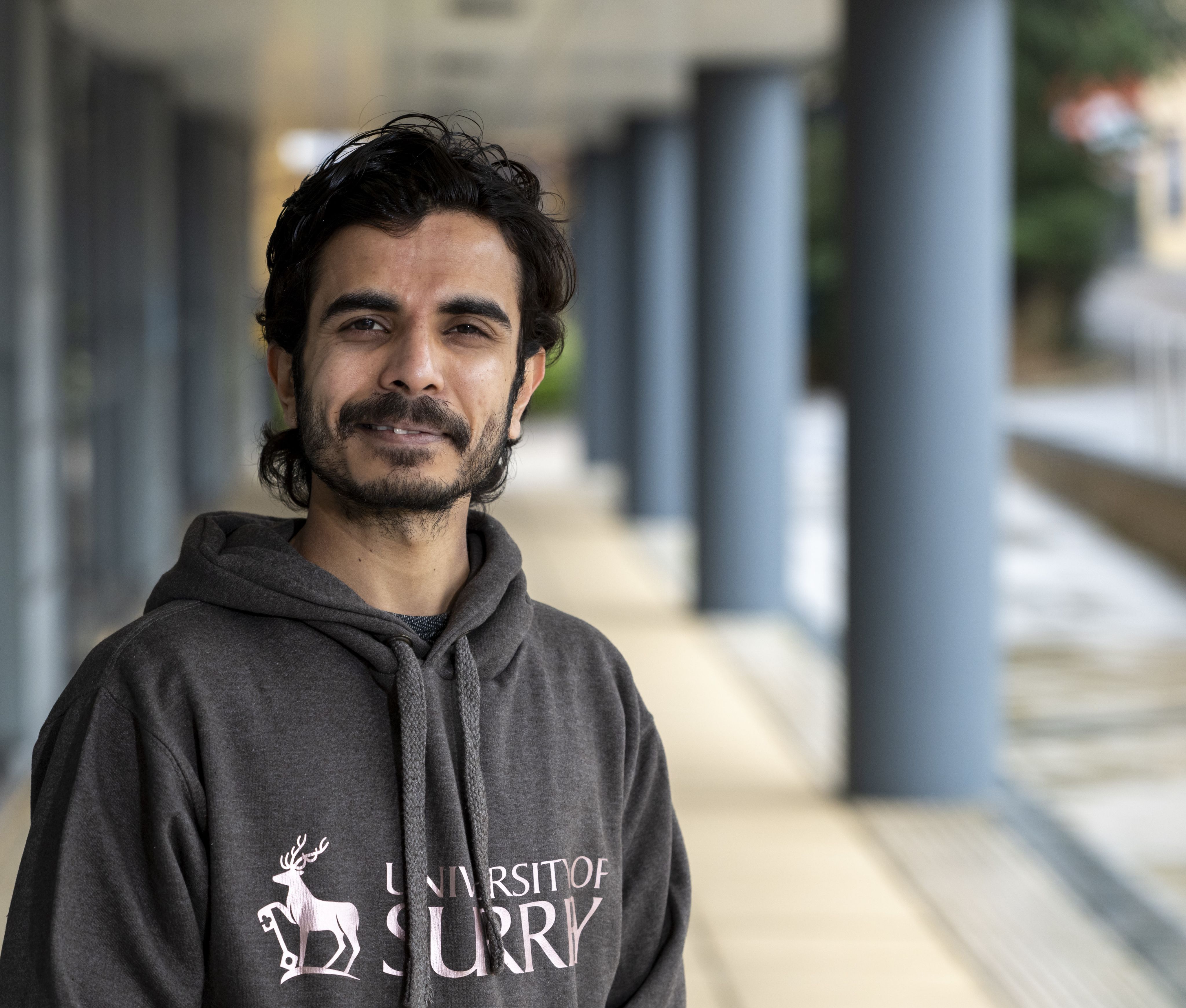 Anirudh Joshi smiles at the camera outside the Surrey Business School