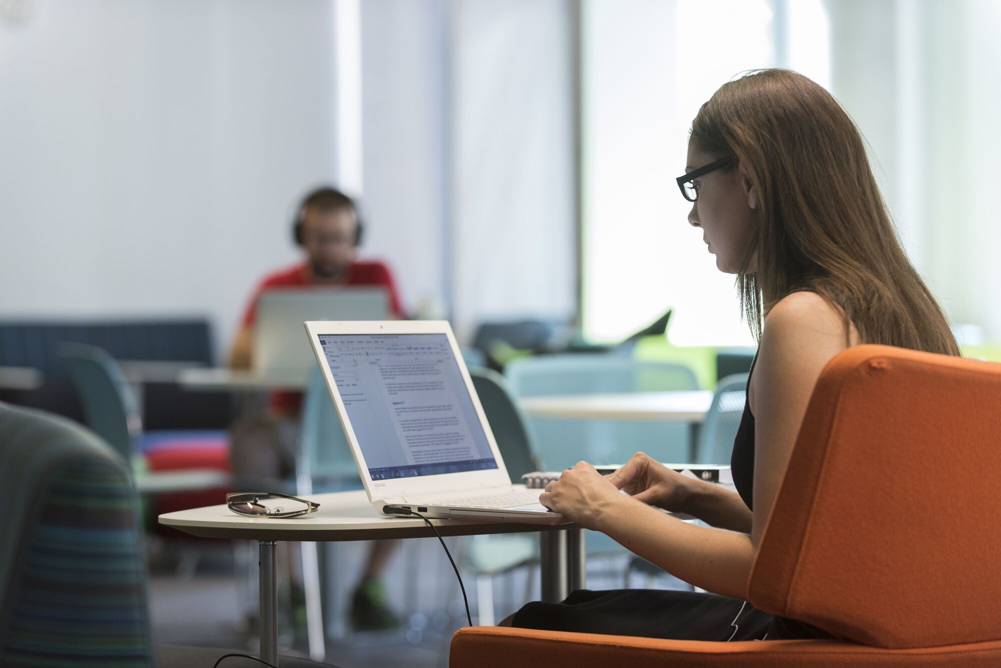 A student works at a laptop in the library